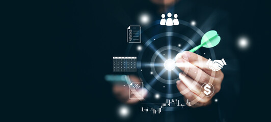 Business goal setting and targeting concept. A man with a dart in his hand aiming at the target to acheive objectives. Strategy and action plan