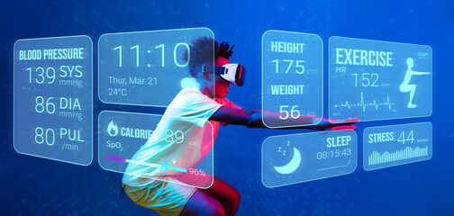 African man wearing VR goggle and white shirt looking at hologram and exercising. Male model squatting at blue background or using artificial intelligence. Technology innovation concept. Ingenuity.