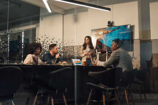 Ecologist with solar panel in hands having seminar with diverse team.