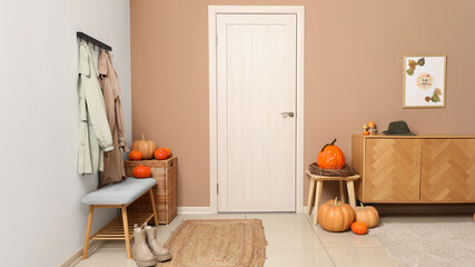 Interior of hallway with autumn decor, door and soft bench