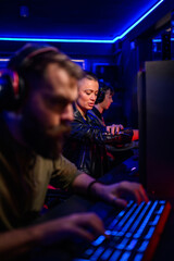 Gamers playing video games while their friend is preparing for tournament.