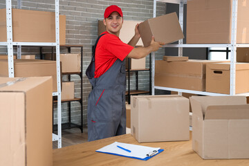 Delivery man taking parcel box from shelf in warehouse