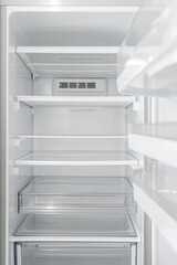 Empty white refrigerator with open door showing clean organized shelves