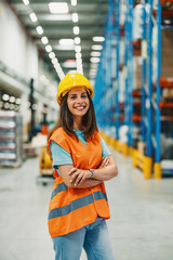 Female employee standing in bright warehouse with supportive smile.