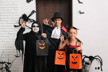 Kids dressed for Halloween with gift bags at door in hall