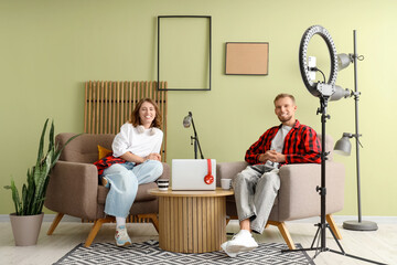 Young woman with man recording podcast in studio