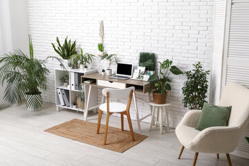 Interior of office with workplace, shelf unit and green plants