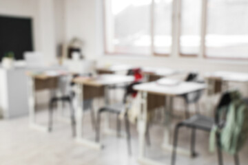 Blurred view of empty classroom with school desks