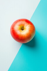 Top view of an apple on a white and light blue background, with hard shadows, in a minimalist style. This is a studio photography product shot with bright light, sharp focus, and professional 