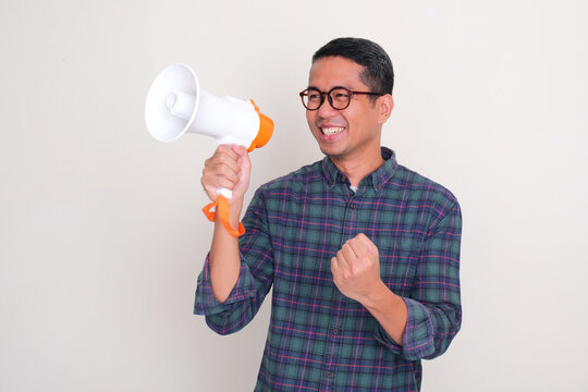 A man clenched fist and showing happy face while holding megaphone