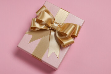 Gift box with bow on dusty pink background