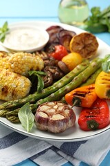 Delicious grilled vegetables on light blue table, closeup
