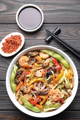 Stir-fry noodles with sea food served on wooden table, flat lay