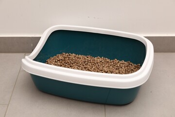 Cat litter tray with filler on floor indoors