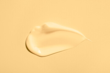 Sample of face cream on beige background, top view