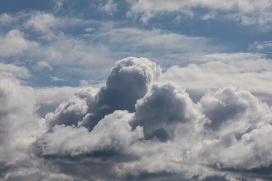 Photograph of multiple types of clouds, large puffy white cotton like clouds both cumulus and cirrus clouds.