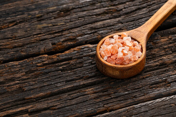 Fine pink salt crystals on wooden spoon - Exotic ingredient for cooking