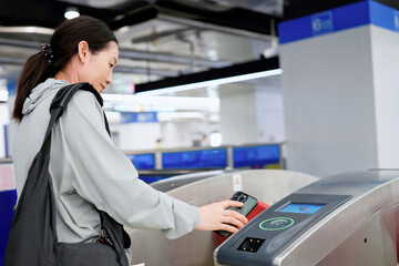 Young Woman Using Contactless Payment at Subway Entrance