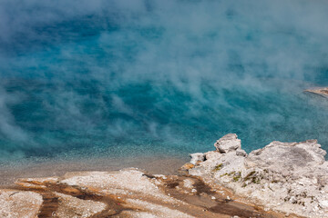 Close up photo of turquoise pool at the Midway Geyser Basin At Yellowstone national park, Wyoming. Hot steam rising from water surface