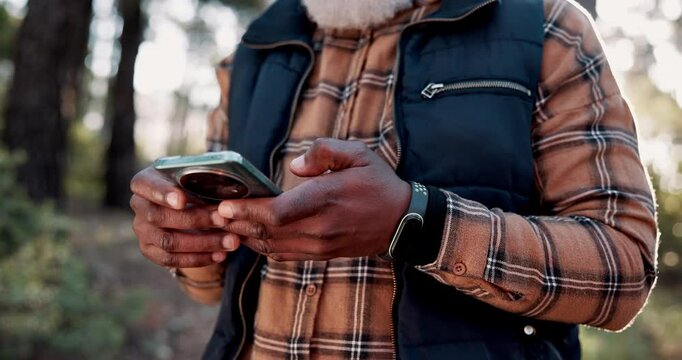 Hiking, smartphone and man with nature, hands and typing for direction, digital app and hobby. African person, traveller and hiker with cellphone, social media and internet with trees and mobile user