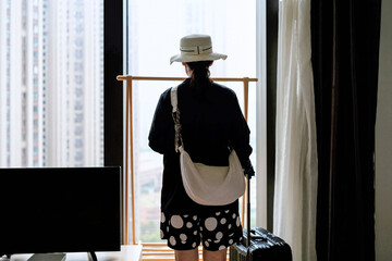 Contemplating Getaway: A Woman Prepares for Travel with City View