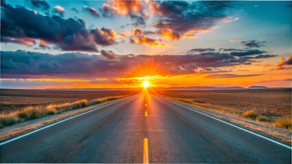 Obraz premium A long, empty road stretches into the distance, illuminated by a vibrant sunset casting warm hues across the sky.