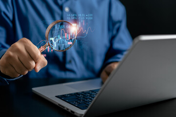 Businessman use magnifier glass find stock in stock markets, uptrends, growth economics, business strategy development, and opportunities for investment, take profit from funds, Financial Analyst.