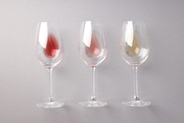 Glasses with different types of wine, on a gray background.