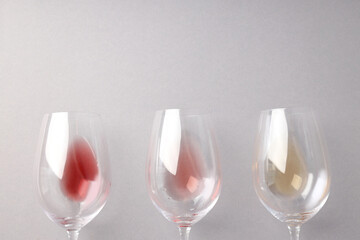 Glasses with different types of wine, on a gray background.
