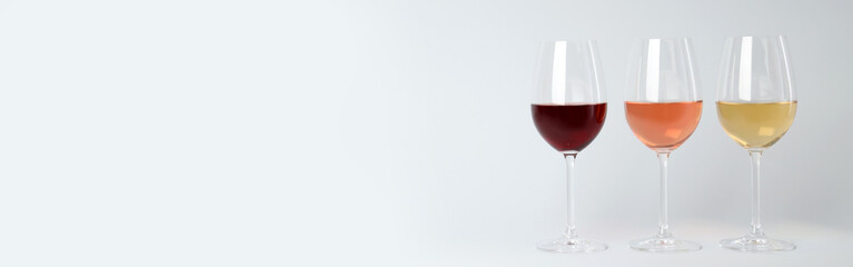 Glasses with different types of wine, on a gray background.