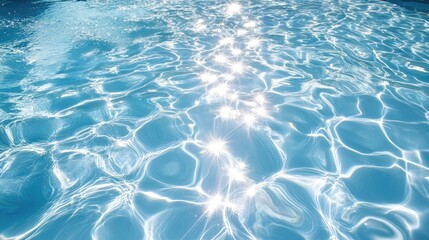 Obraz premium A shimmering blue pool surface reflects sunlight, creating a beautiful pattern of light and water ripples.