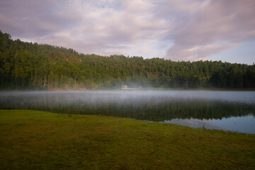 Cold and foggy morning. Cozy cabin in the forest.
