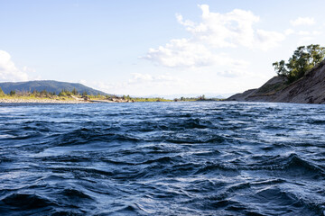 Water surface photo. Close up image of deep blue rippling river water surface beautiful calming bight day with white cloud in the sky.