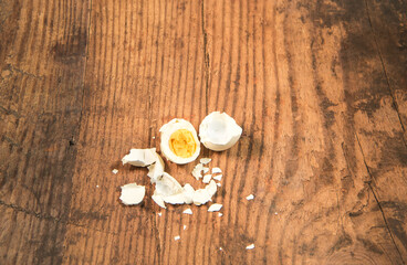Peeled fresh organic eggs isolated on a rustic wooden table with advertising space.