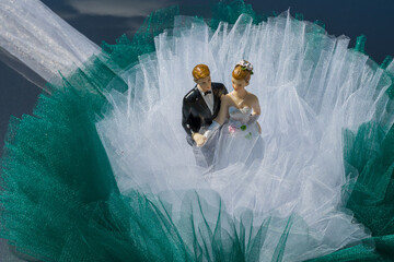 Bride and groom couple miniature on the bride and groom's car ,2024