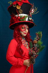 Portrait of woman with beautiful Christmas makeup, wearing huge hat with Christmas decorations.