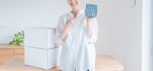電卓で引越し費用の見積もりをする女性