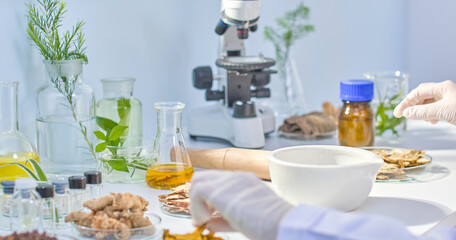 This photo of a modern lab experiment in Oriental Medicine features a scientist holding a piece of...