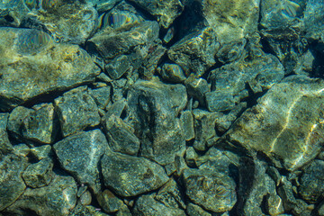 Top down view of mesmerizing view of stones submerged in the crystal-clear waters of the sea. The...