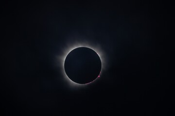 A stunning view of a solar eclipse, showcasing the dark silhouette of the moon completely covering the sun, with a halo of light around the edges.
