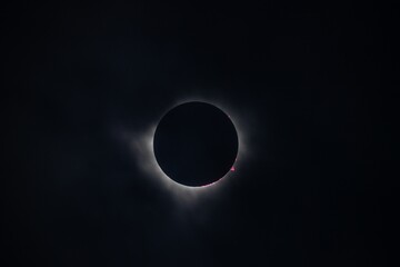 A stunning view of a solar eclipse, showcasing the dark silhouette of the moon completely covering the sun, with a halo of light around the edges.