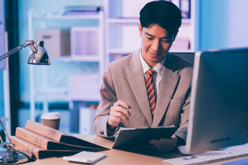 Businessman working hard overtime at night at the office. He felt tired and stressed from work.
