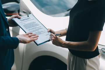 A young businesswoman is navigating car insurance options at her desk, considering premiums,...