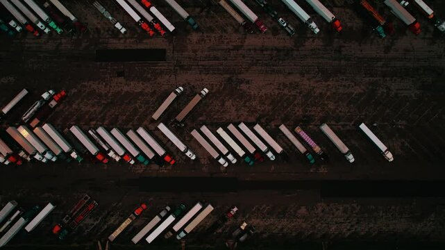 Top down of symetric semi trucks parked at night truck stop. Moody aerial Wisconsin, USA.