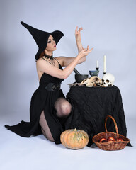  portrait of beautiful female model wearing glamorous black witch dress, pointy hat halloween...