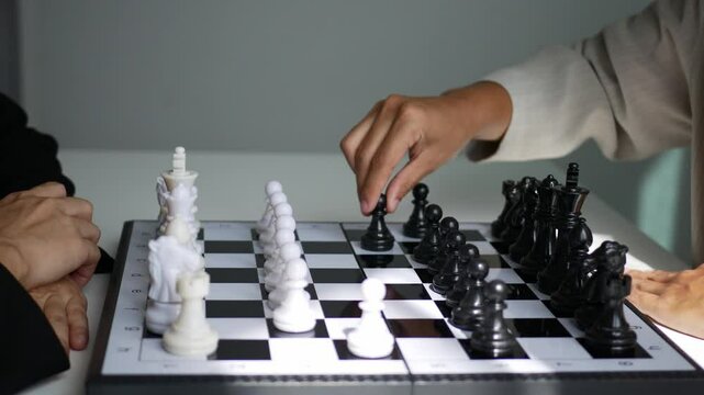 Two business women play a game of chess to be a concept of business competition and problem solving For always good results.