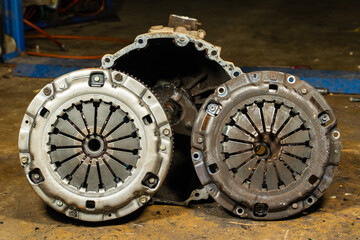 Old Vs new clutch plate in car, clutch system,Truck clutch system repair.The mechanic is repairing the car's clutch system.