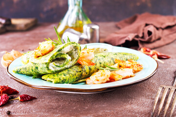 Green pancakes close-up with shrimps stuffing and cheese