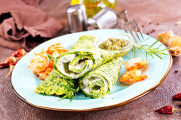 Green pancakes close-up with shrimps stuffing and cheese