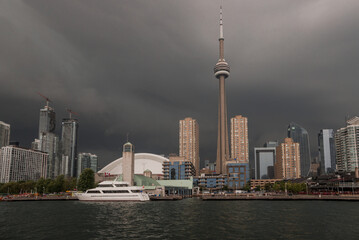 Before the storm - city skyline panorama, calm water and storm clouds approaching the city. Rough weather, dramatic sky, thunderstorm, dark clouds. Toronto, Ontario, Canada